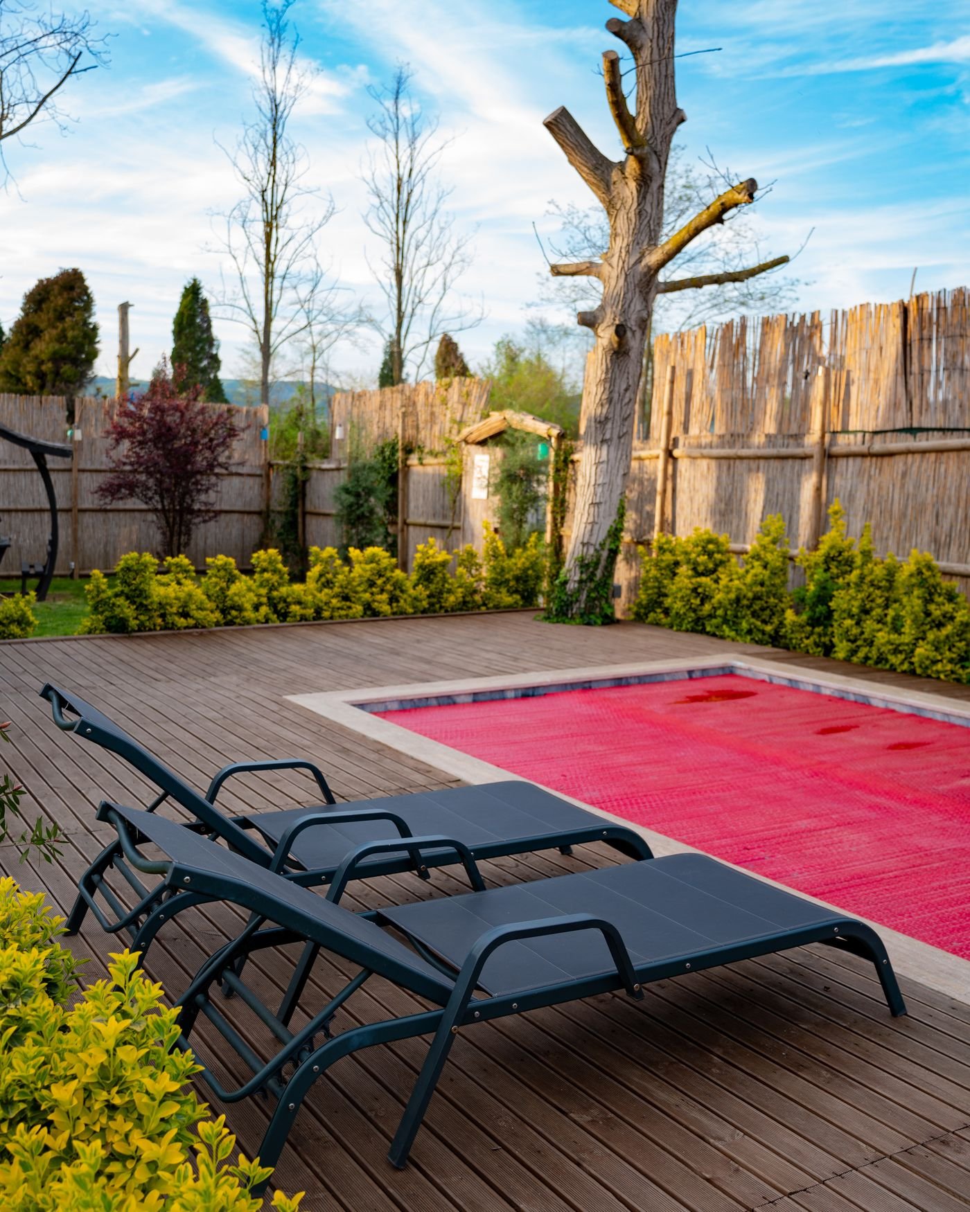 Above ground pool ideas: wooden deck surround beside a backyard swimming pool
