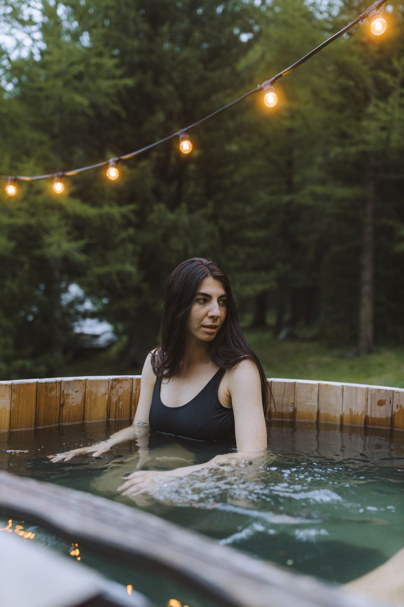 Cheap backyard pool lighting: outdoor hot tub glowing under string lights at night