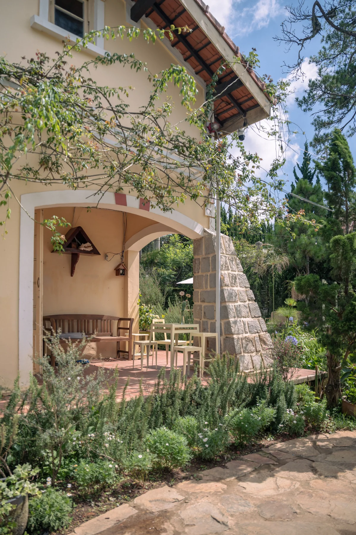 Cottage patio with terracotta roof overhang matching house gable roof
