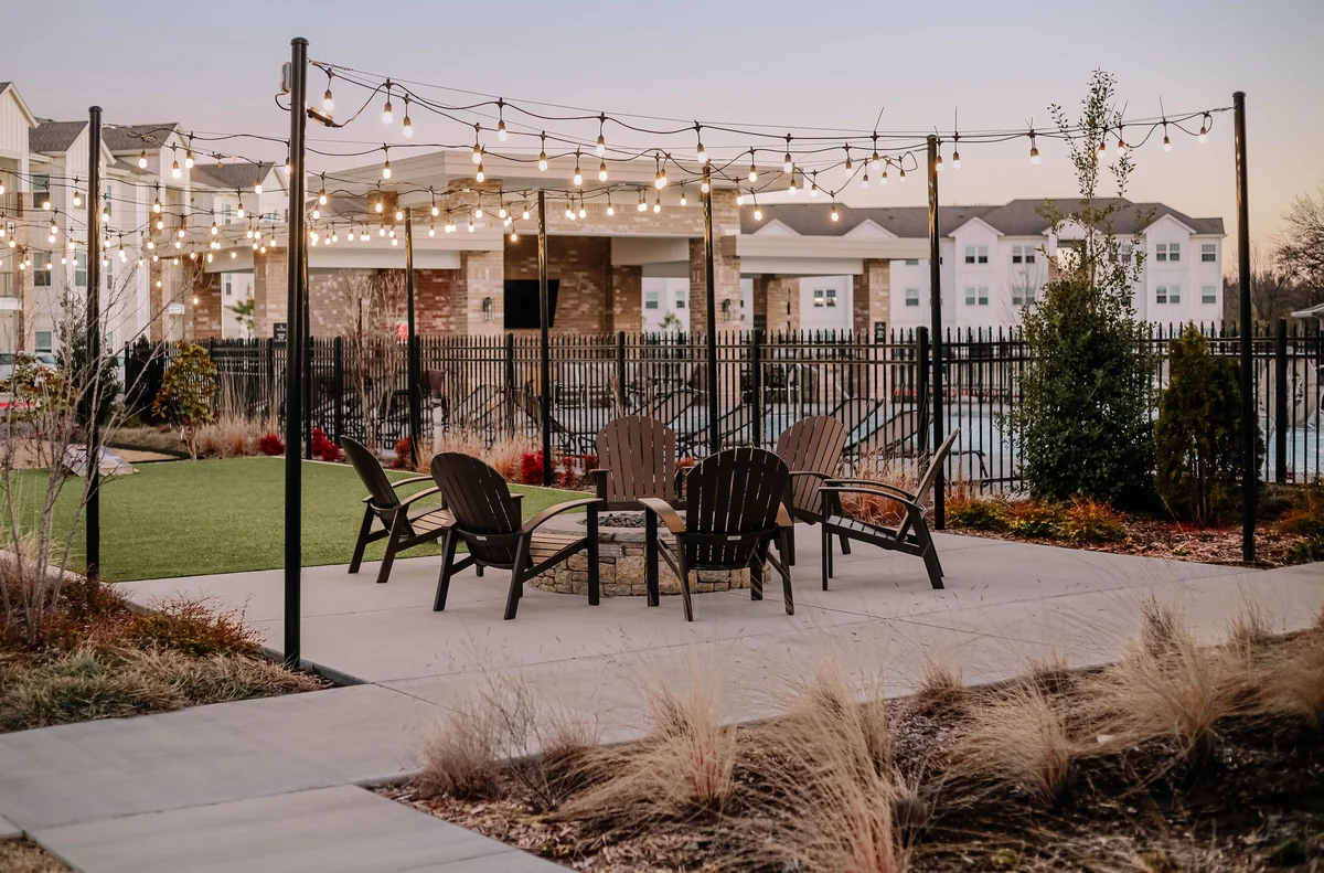 String lights glowing over patio at dusk under gable roof cover
