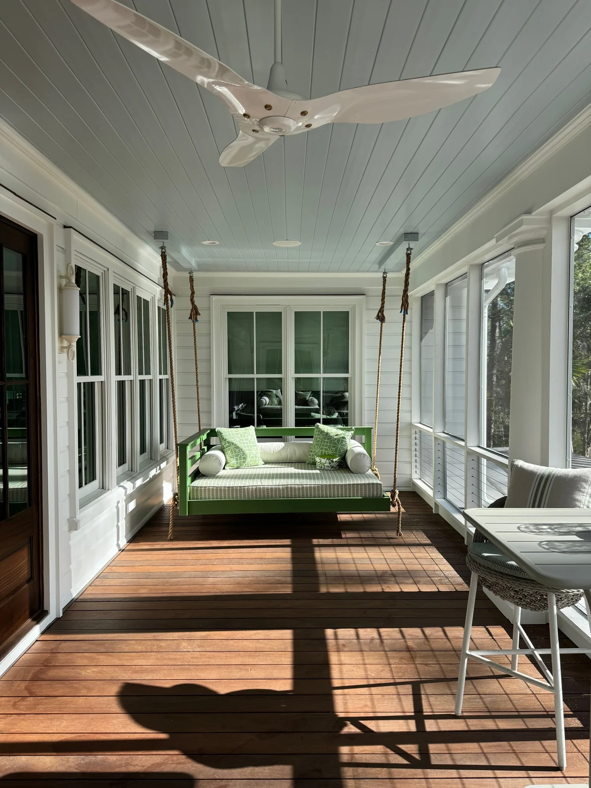 Vaulted beadboard ceiling with ceiling fan on gable roof patio