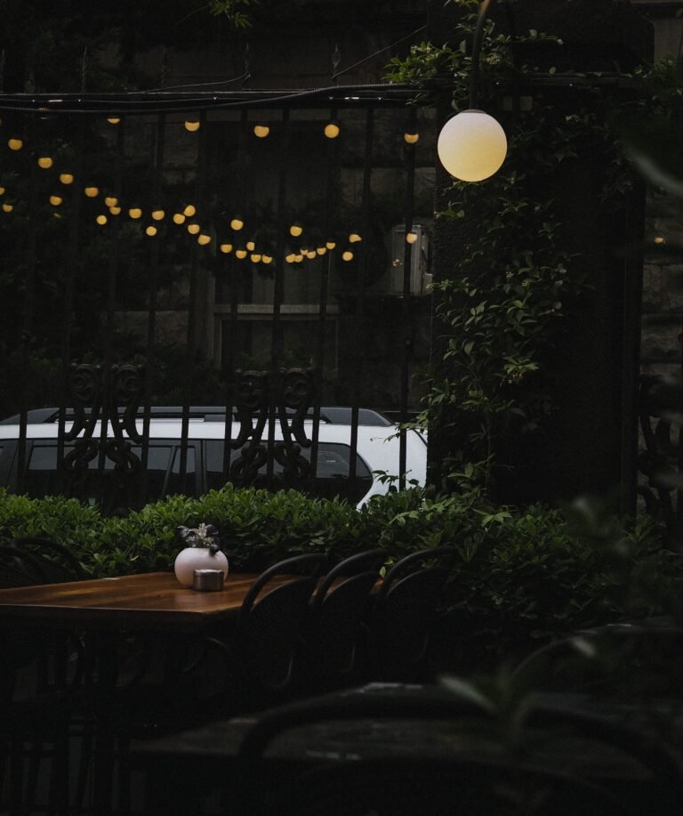 Moody patio decor ideas with dark furniture and amber lighting at dusk