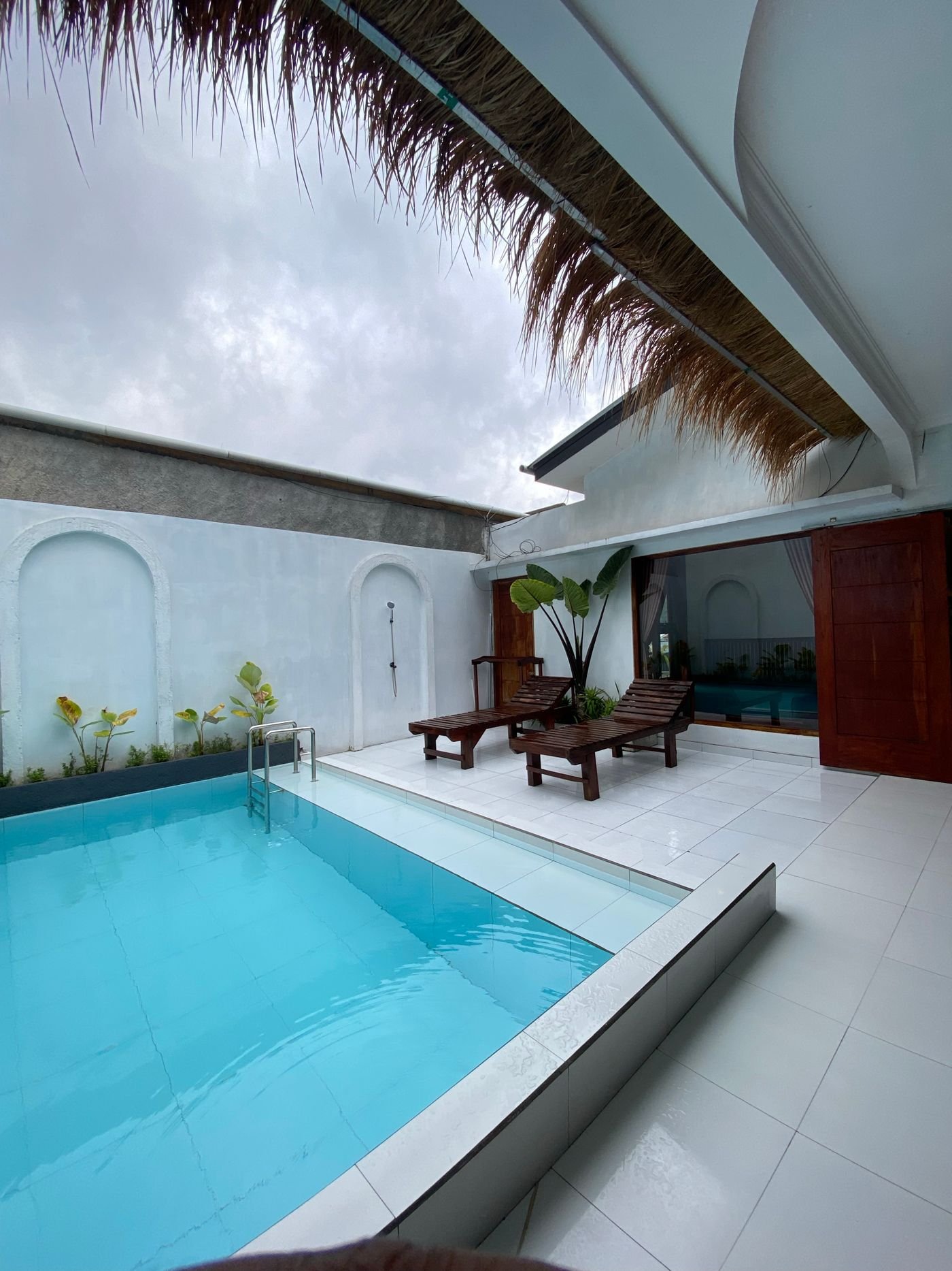 Poolside shade ideas: lounge chairs under a canopy beside a backyard pool