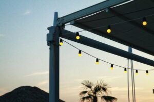 Multiple strands of outdoor string lights on a patio at sunset