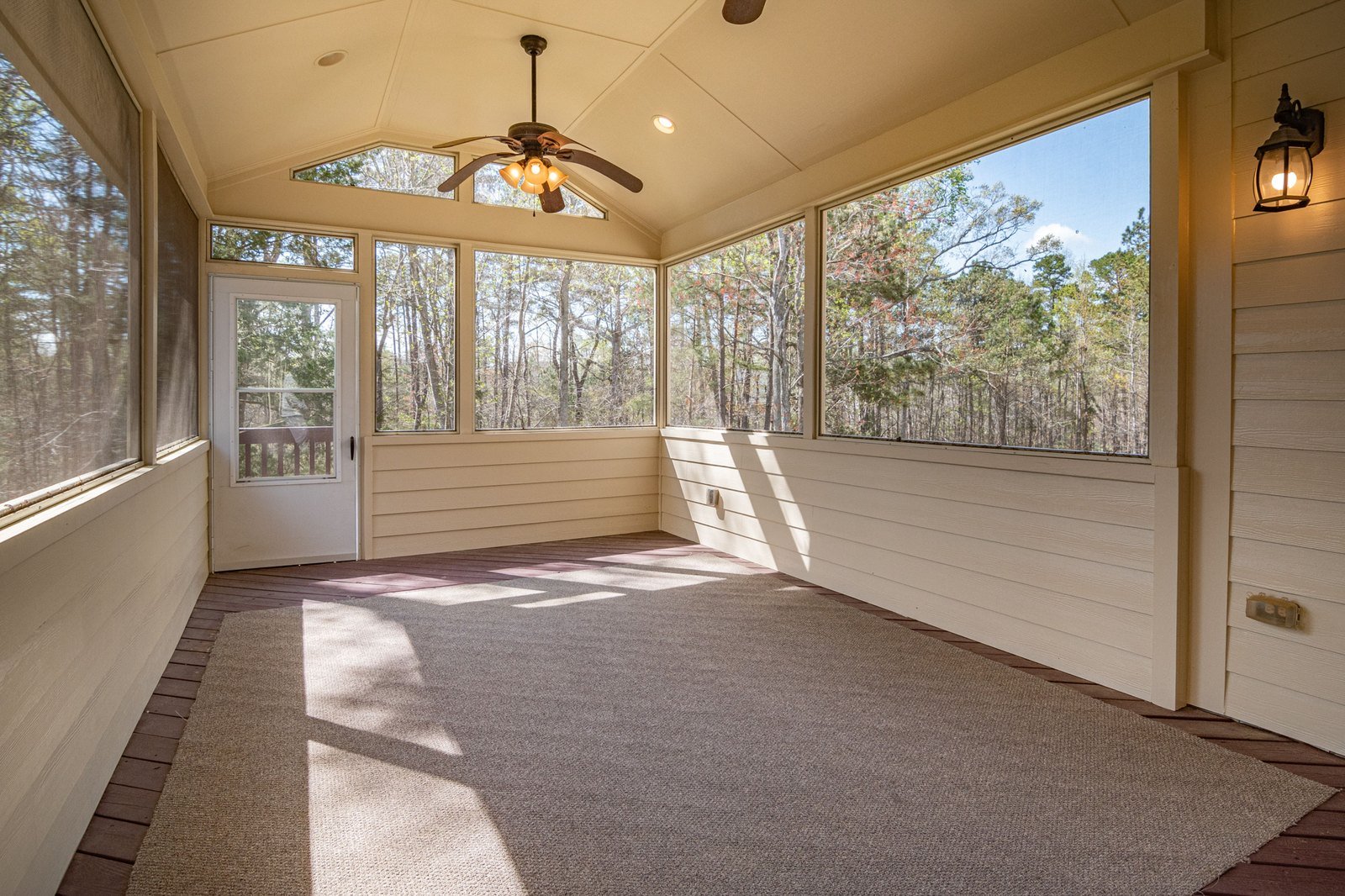 Enclosed porch with clear vinyl patio enclosure panels and ceiling fan