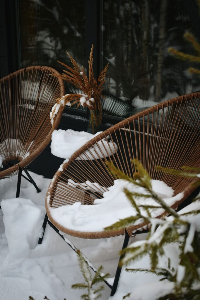 Winter patio decor — wicker chairs covered in fresh snow