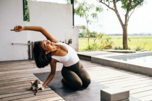 Backyard yoga space ideas — woman practicing yoga on a deck patio at sunrise